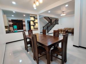 a dining room and living room with a wooden table and chairs at Highway Twin Home East wing in Kadawatha