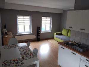 a kitchen and living room with a couch and a table at Apartamenty Dominik in Wiele