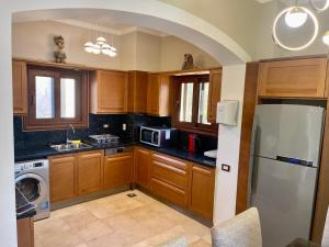 a kitchen with wooden cabinets and a stainless steel refrigerator at Y 140 wast golf heated private pool in Hurghada