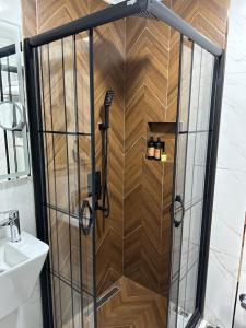 eine Dusche im Bad mit einer Holzwand in der Unterkunft Blue Tuana Hotel in Istanbul
