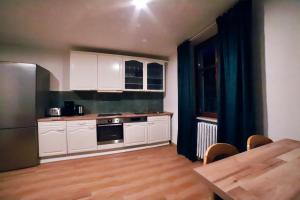 eine Küche mit weißen Schränken, einem Holztisch und einem Tisch in der Unterkunft Gasthaus zur Krone in Weisenbach