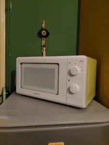 a microwave sitting on top of a refrigerator at Φιλοξενία1 in Drama