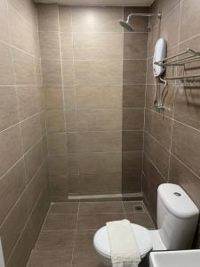 a bathroom with a toilet and a phone on the wall at Melati Tanjong Beach Resort in Pantai Cenang