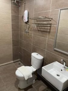 a bathroom with a toilet and a sink at Melati Tanjong Beach Resort in Pantai Cenang