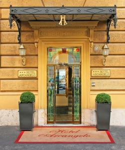 a door to a building with two plants in front at Hotel Arcangelo in Rome