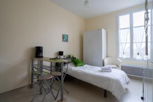 1 dormitorio con cama, escritorio y nevera en Les Jardins De La Seugne, en Jonzac