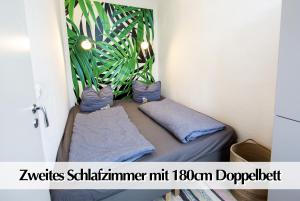 Cette chambre comprend un lit avec des plantes sur le mur. dans l'établissement 80m2 3R Wohnung mit privatem Parkplatz, Kingsize Betten, Smart-TV, etc, à Erfurt