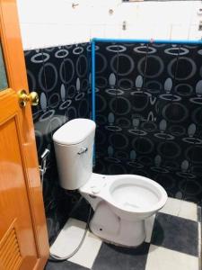 baño con aseo y suelo de baldosa blanco y negro. en Yem Homestay, en Baguio