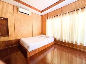 a small bedroom with a bed and a window at Baan Siriporn Resort - โรงแรมบ้านศิริพร รีสอร์ท in Samut Songkhram