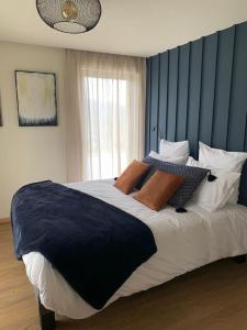 ein Schlafzimmer mit einem großen Bett mit Kissen darauf in der Unterkunft Gîte "Villa Belle Vie" in Labaroche