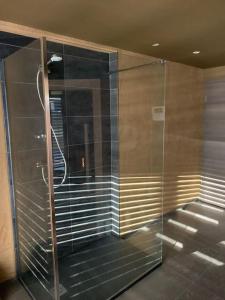 eine ebenerdige Dusche mit Glastüren in einem Zimmer in der Unterkunft Gîte "Villa Belle Vie" in Labaroche