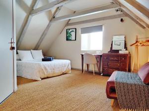 a bedroom with a bed and a desk in a attic at Maison d'Hôtes La Grange in Salers