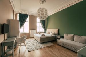 ein grünes Wohnzimmer mit einem Sofa und einem Tisch in der Unterkunft Luga Homes - Stadthaus in Leipzig