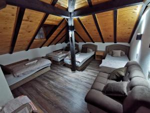 a living room with a couch in a room with wooden ceilings at Pansion Oscar Summer Garden in Mostar