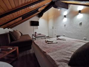 a bedroom with a large bed and a couch at Pansion Oscar Summer Garden in Mostar