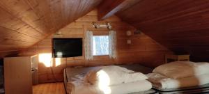 a bedroom with two beds in a wooden cabin at Punatulkku in Kalajoki