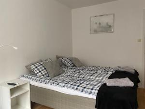a small bedroom with a bed and a night stand at A&M in Nynäshamn