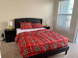 a bedroom with a bed with a red blanket and pillows at A Cozy /Luxury One bedroom in Downtown Indy in Indianapolis