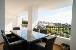 uma sala de jantar com mesa e cadeiras e uma varanda em Los Robles de Los Arqueros golf 3 bedrooms apartment. em Benahavís