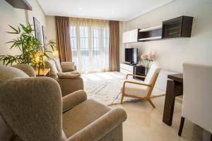 salon z kanapą, krzesłami i telewizorem w obiekcie Los Robles de Los Arqueros golf 3 bedrooms apartment. w mieście Benahavís