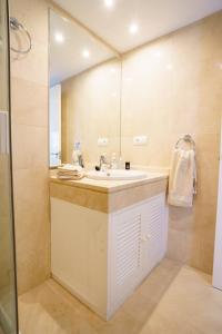 uma casa de banho com um lavatório e um espelho em Los Robles de Los Arqueros golf 3 bedrooms apartment. em Benahavís