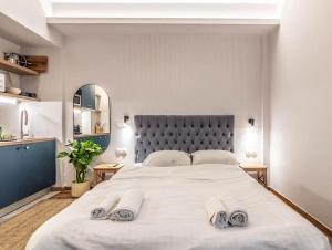 um quarto com uma grande cama branca com duas toalhas em Blue Truffle em Atenas