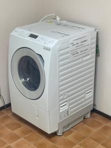 a white washing machine sitting next to a wall at Guest House MEETS Okayama 全室個室のホステル in Okayama
