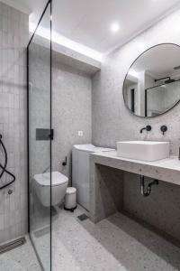 uma casa de banho com um lavatório, um WC e um espelho. em Blue Truffle em Atenas