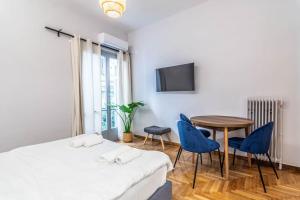 um quarto de hotel com uma cama, uma mesa e cadeiras em Blue Truffle em Atenas