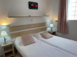 two twin beds in a room with two lamps at Villa LA FAMILIA maison traditionnelle in Plakias