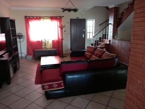 ラゴスにあるMy Friendly Houseのリビングルーム(黒いソファ、赤い家具付)