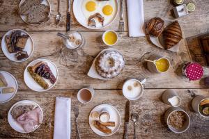 a table with plates of breakfast foods and coffee at Relais et Châteaux Le Chambard in Kaysersberg