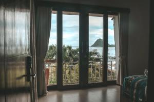 a room with sliding glass doors with a view of the ocean at Escape Bajo in Labuan Bajo