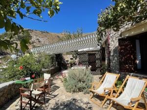 a group of chairs and a table in a garden at Villa LA FAMILIA maison traditionnelle in Plakias