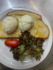 a plate of eggs and bread with broccoli and a tomato at La Veranda Hotel in Larnaca