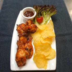 a plate of food with chicken and chips and broccoli at La Veranda Hotel in Larnaca