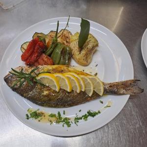 a plate of fish and vegetables on a table at La Veranda Hotel in Larnaca