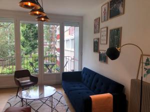 a living room with a blue couch and a glass table at 75 m2 # logia & parking gratuit # BESTOFBLO 4 # in Fontainebleau
