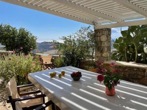 a white table with fruits and flowers on a patio at Villa LA FAMILIA maison traditionnelle in Plakias