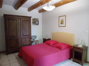 1 dormitorio con 1 cama grande con colcha rosa en gîte de Vialette, 