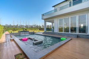 een huis met een zwembad met twee frisbees erin bij StayVista at Colour Bloom - Pet Friendly Home with Swimming Pool 