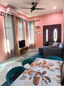 - un salon avec un lit et une télévision dans l'établissement NazLa Homestay Pendang, à Pendang