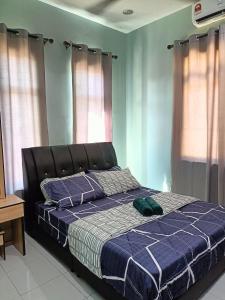 a bed in a bedroom with blue walls and windows at NazLa Homestay Pendang in Pendang