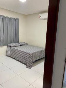 a small bed in a room with a window at Chacara Pe. Cicero in Triunfo +23 photos