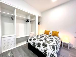 een slaapkamer met een bed met een zwart-witte deken bij Cool Space in Madrid