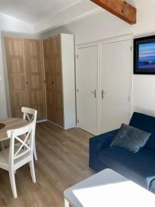 sala de estar con sofá azul y mesa en Charming 1 bedroom flat, Biarritz center with pool and car park, en Biarritz