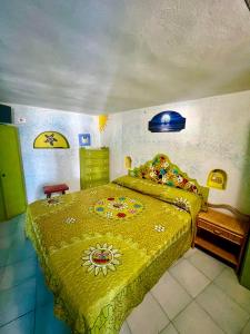 a bedroom with a bed with a yellow bedspread at Holiday Home Case Blu in Lipari