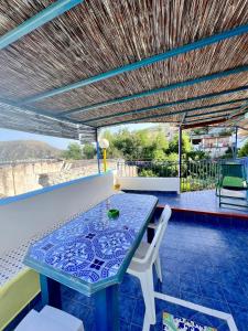 einen blauen Glastisch und Stühle auf einer Terrasse in der Unterkunft Holiday Home Case Blu in Lipari