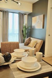 a living room with a table with dishes on it at Modern Minimalist 1 BR Condo in IT Park in Cebu City