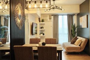 a dining room and living room with a table and chairs at Modern Minimalist 1 BR Condo in IT Park in Cebu City